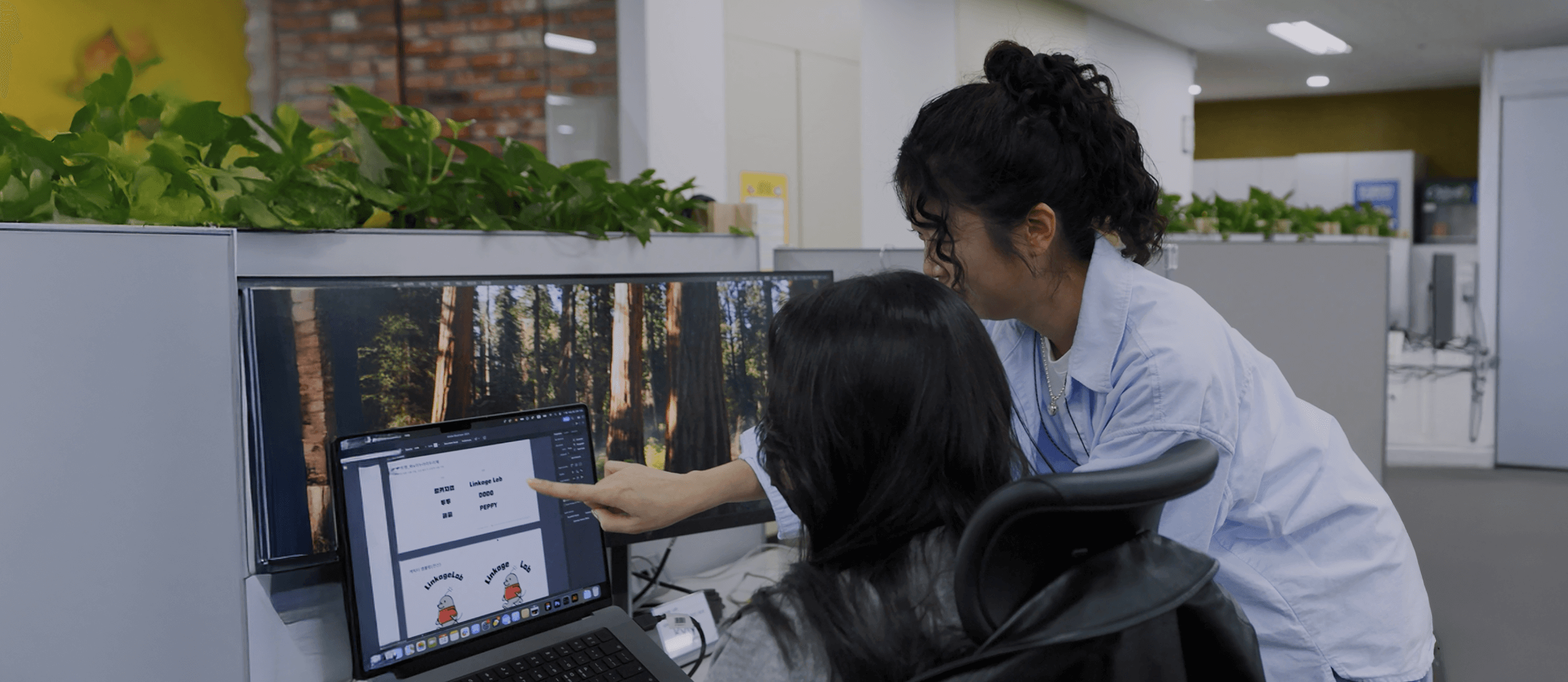 디자인시안을 보며 논의 중인 크루 두 명의 모습